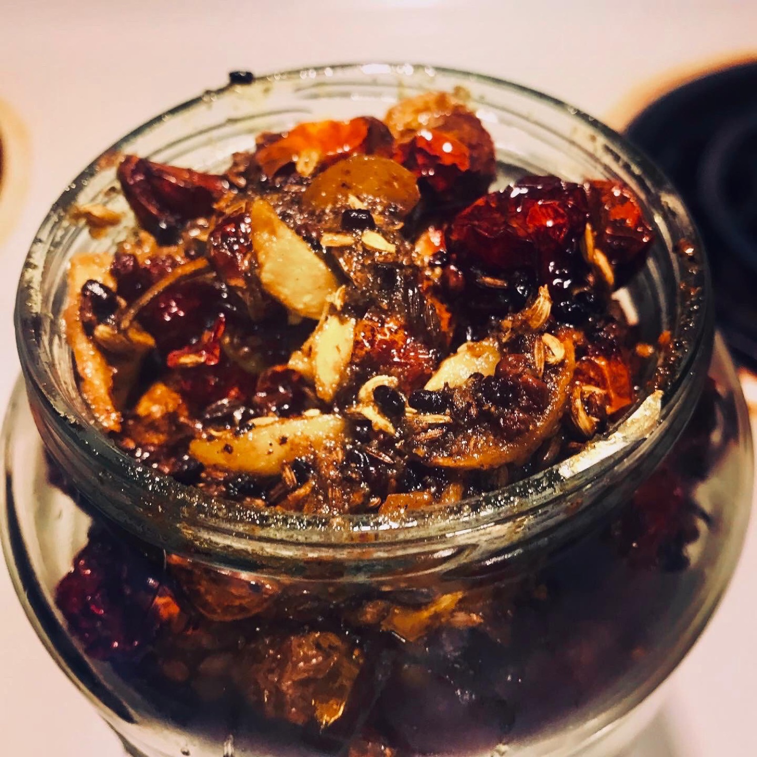 Looking down into an open jar of chili achar with fennel seeds