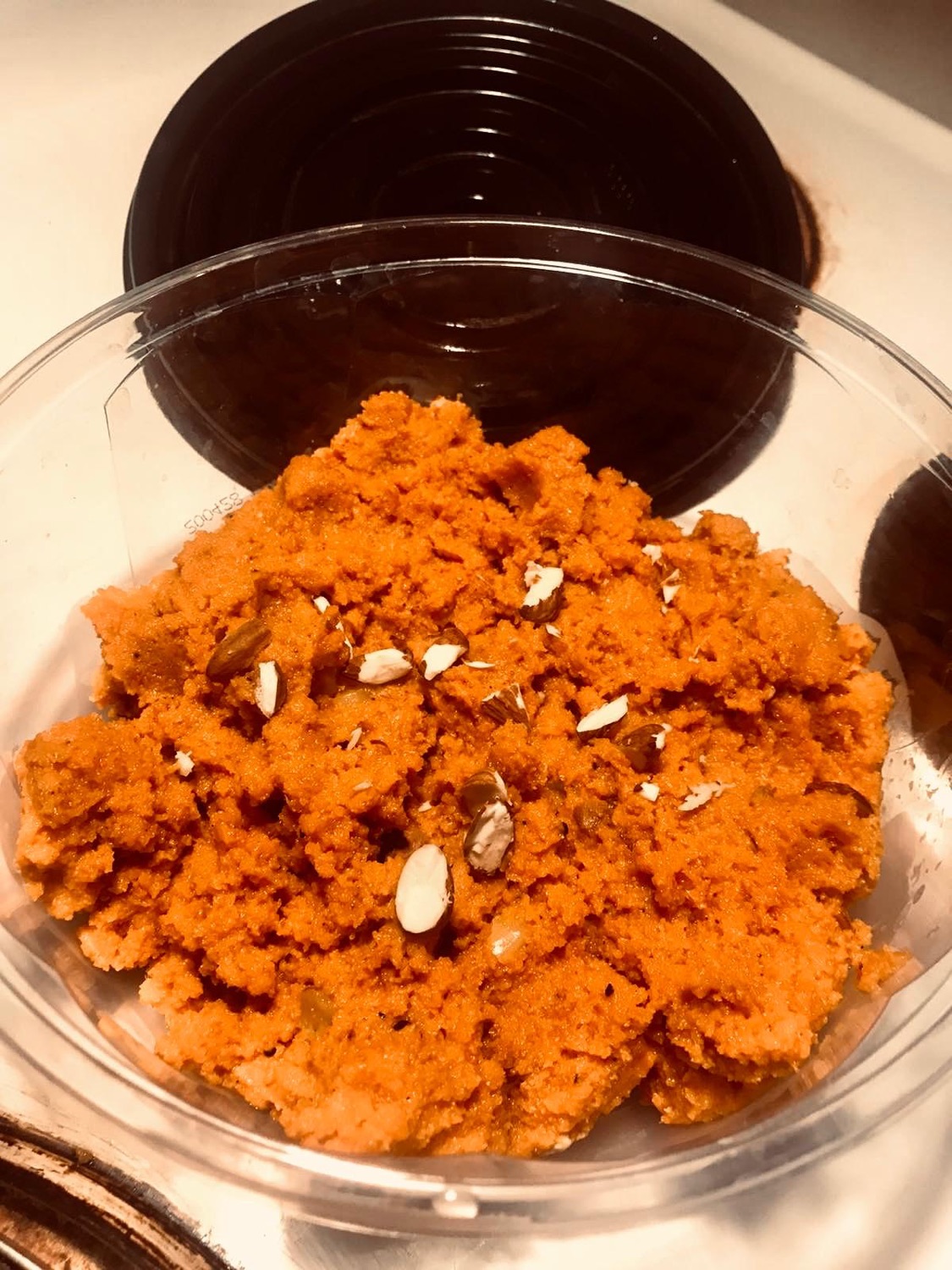 Bright orange carrot halwa topped with slivered almonds