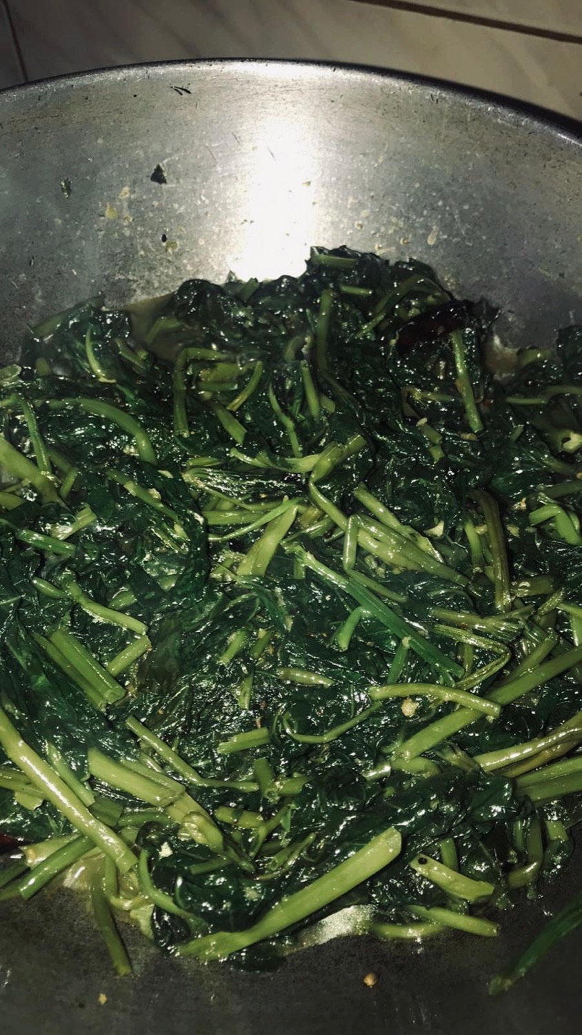 Garlicky sautéed leafy greens in a steel kadhai