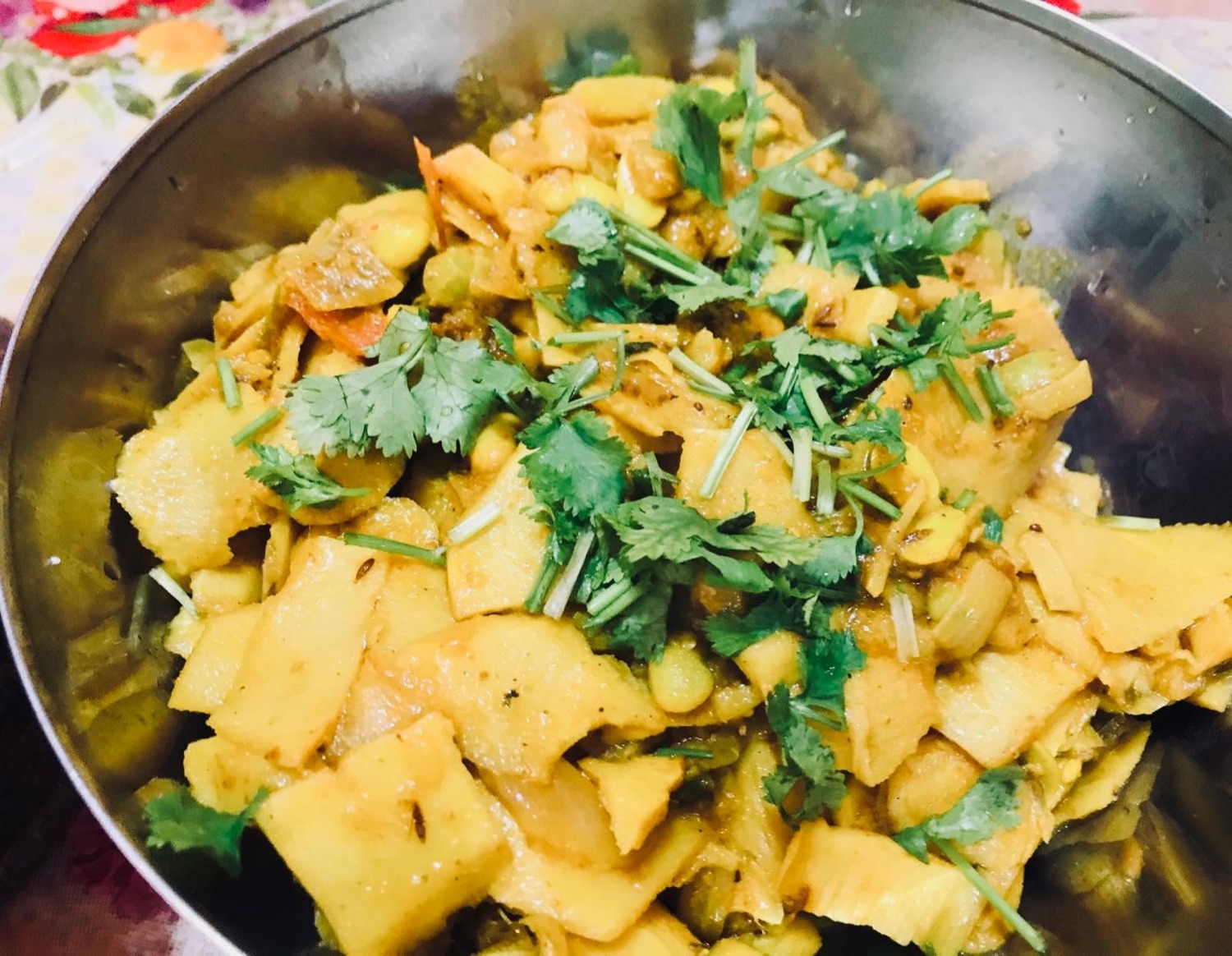 Aloo tama bodi: bamboo shoot curry with potatoes and beans, topped with coriander